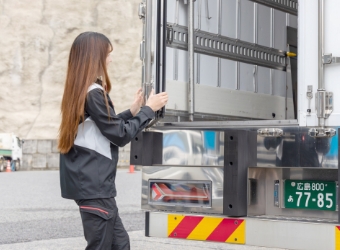 トラックの荷を下ろすドライバー